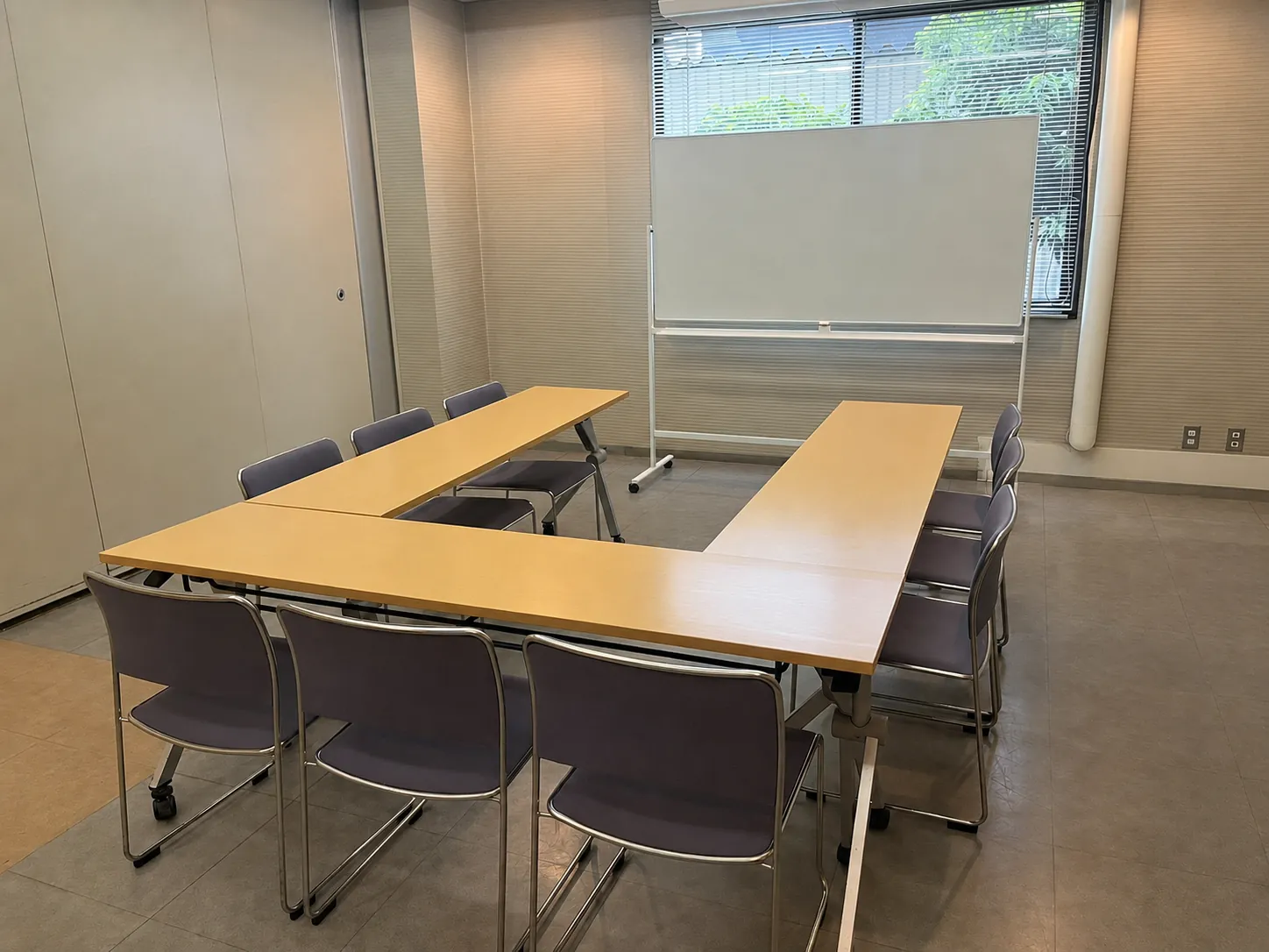 山田ふれあい文化センター会議室(1)の室内。窓際にホワイトボード、コの字に並べた机と椅子