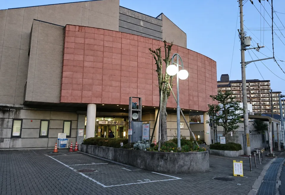 吹田市立山田ふれあい文化センターの外観。赤茶色のタイル壁の建物で、入口前に街灯と植え込みがある